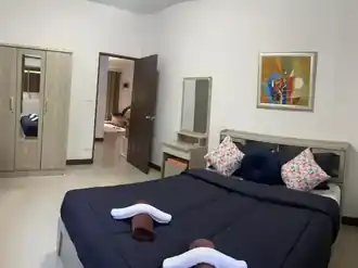 interior bedroom with a large bed and a small dressing table and a wardrobe